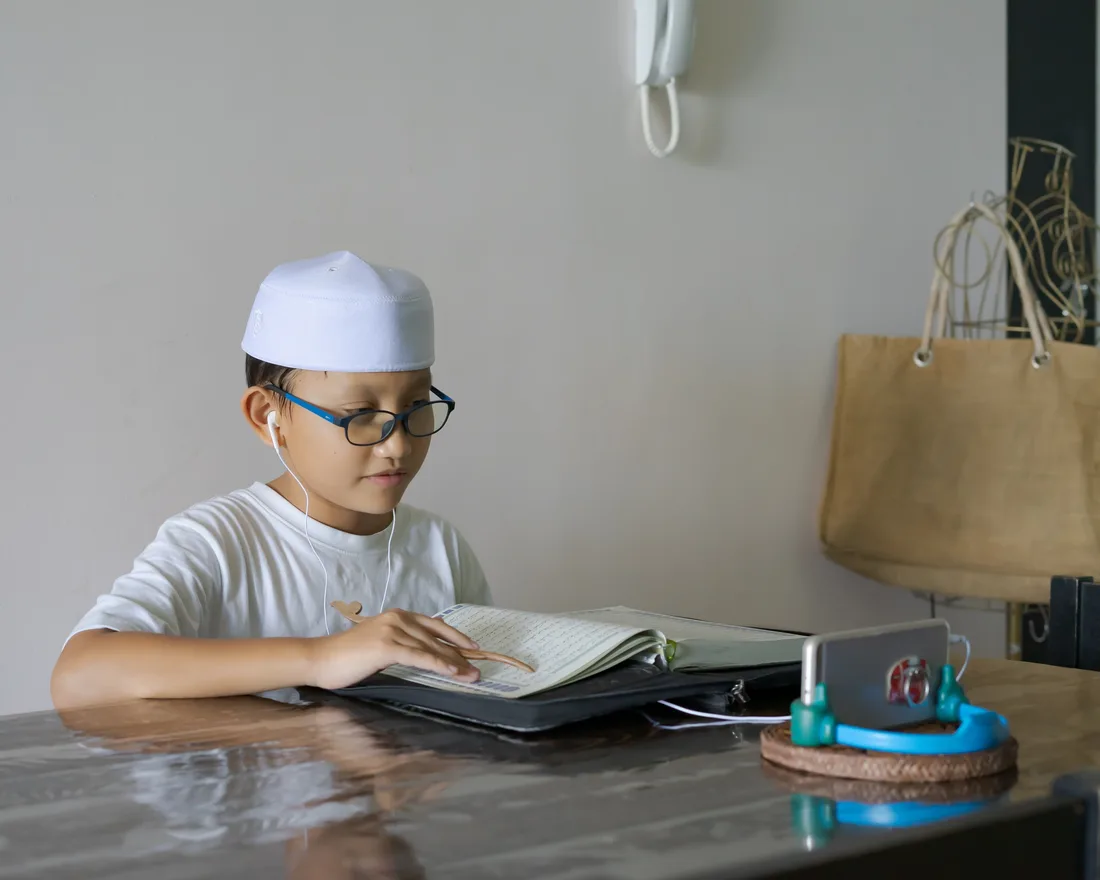 An Arabi student learning to recite the Quran online with focus